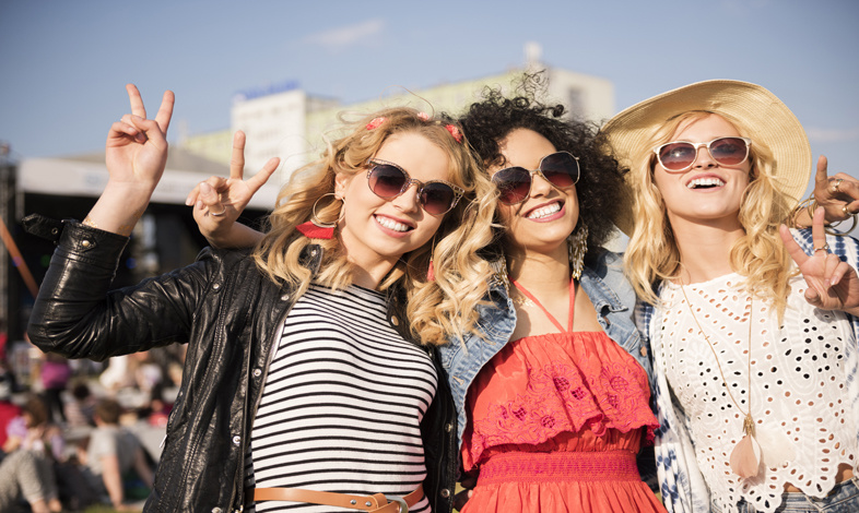 Uśmiechnięte młode kobiety na festiwalu muzycznym