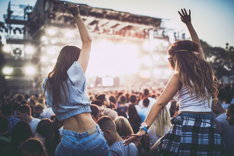 Dwie dziewczyny bawią się pod sceną na festiwalu muzycznym
