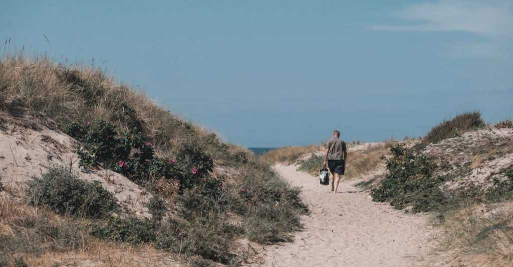 mężczyzna spaceruje po plaży