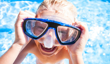 Uśmiechnięte dziecko z maską do nurkowania na basenie