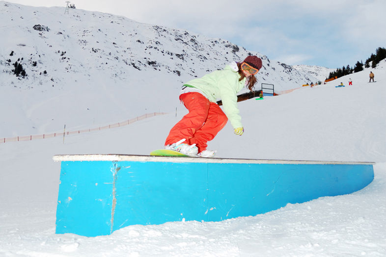 Rider w snowparku na przeszkodzie butter box