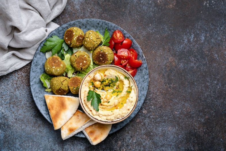 Falafel i hummus na talerzu z pitą i pomidorami 